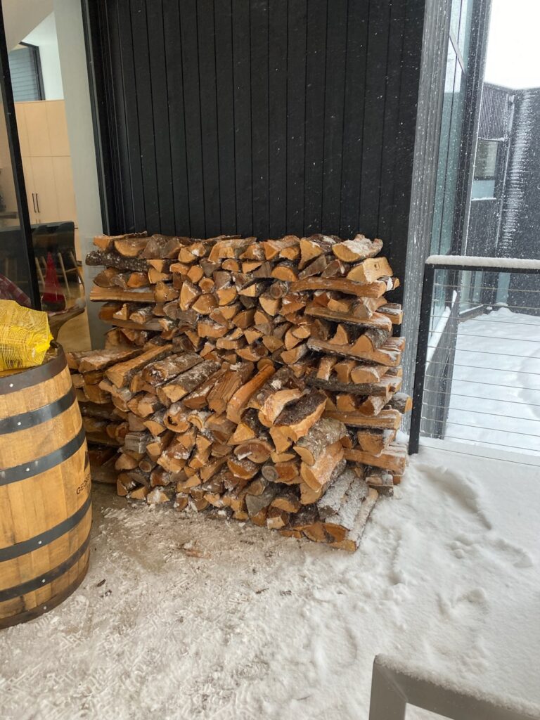 stacked face cord of firewood inside a garage