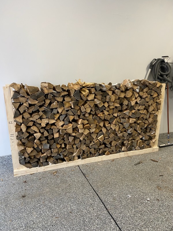 face cord of stacked firewood inside a garage