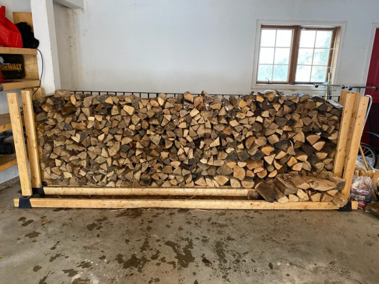 stacked firewood in a garage on a wooden rack