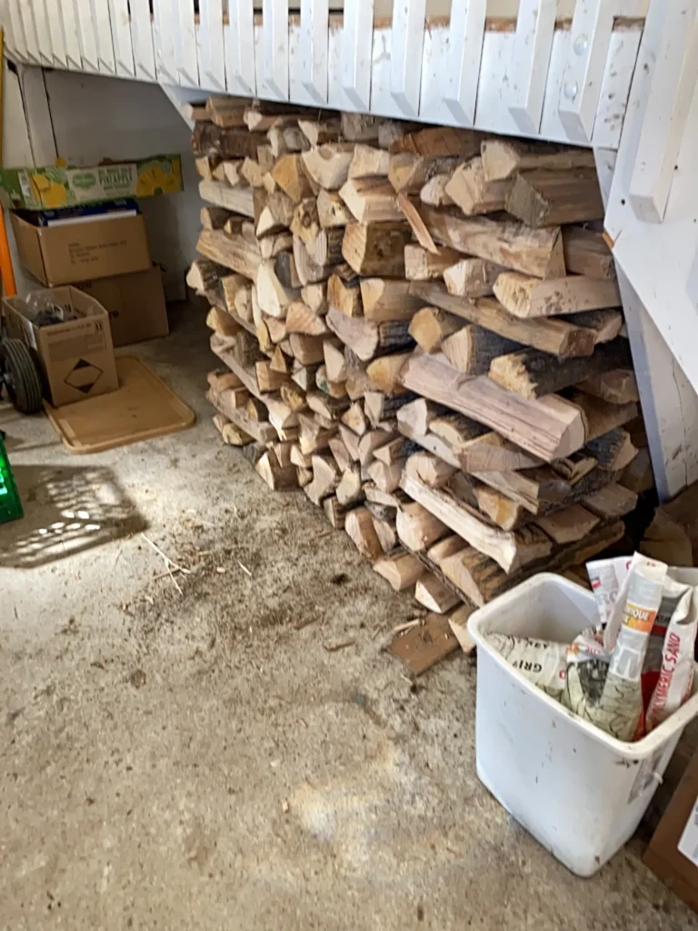 stacked firewood under stairs